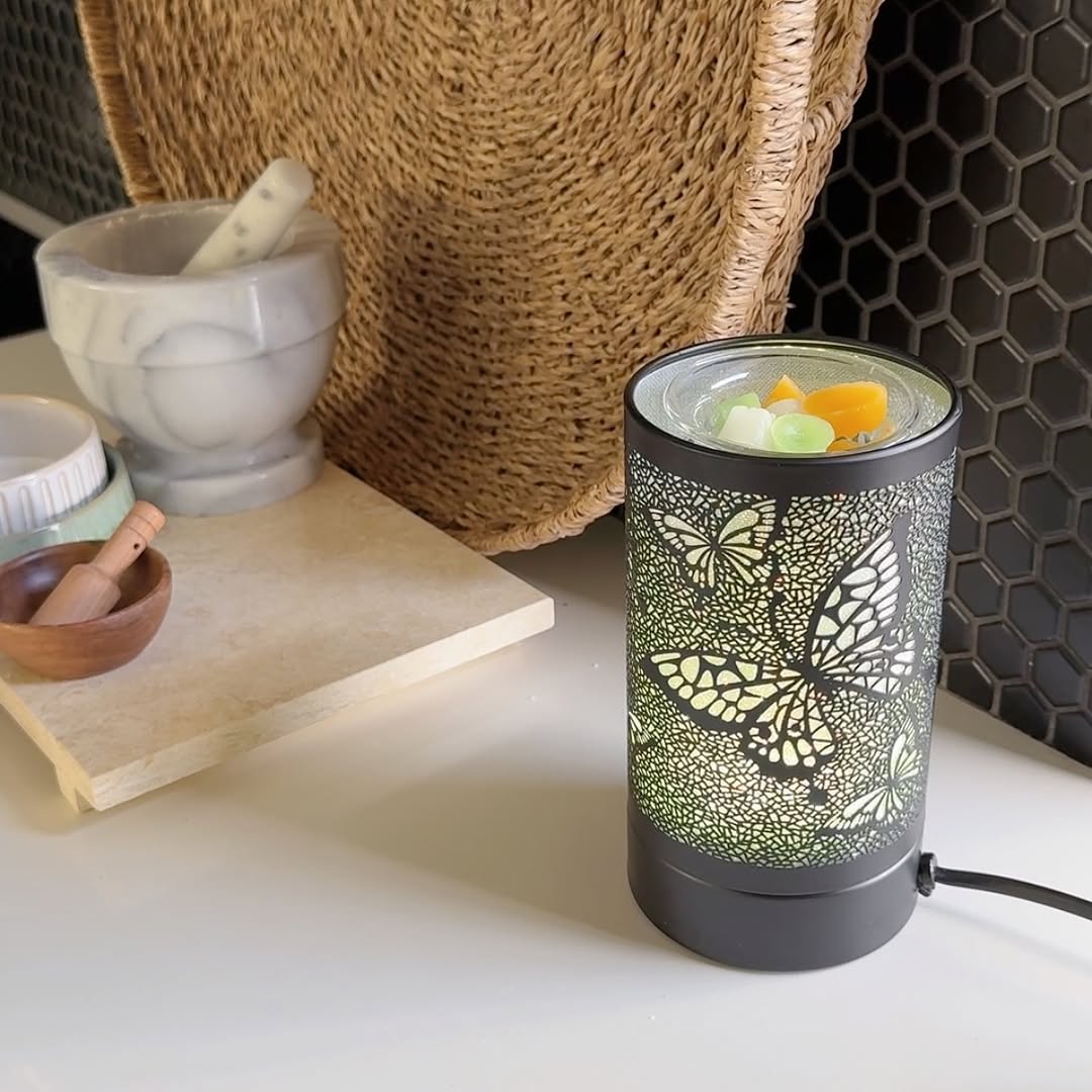 Butterfly LED Wax Warmer and Wax Melt Dish Black butterfly LED wax warmer with a glass dish of pastel wax melts on a home surface